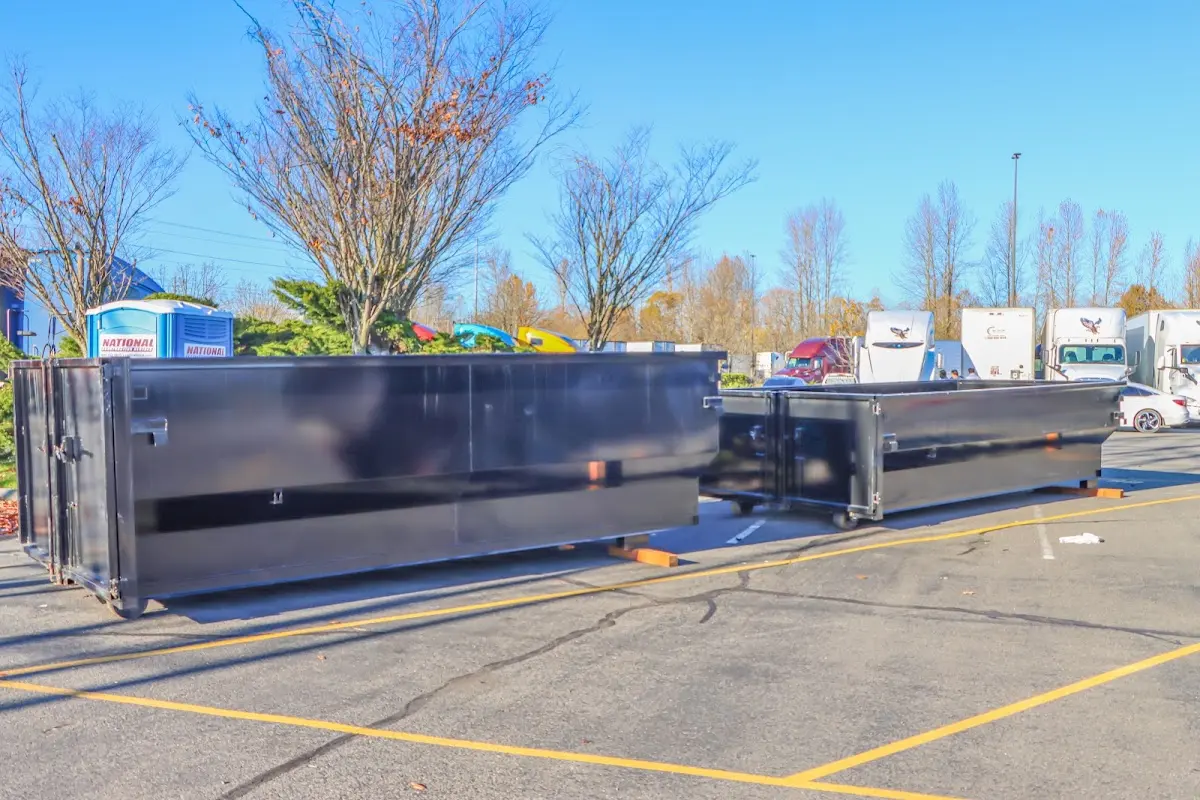 Professional dumpster rental service with roll-off container on residential driveway in San Luis